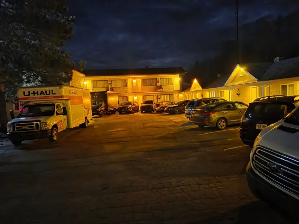 Le Motel Marie-Dan illuminé en soirée, avec des véhicules dans le stationnement